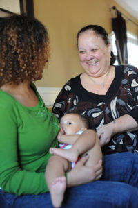 Image of woman breastfeeding with support person smiling at her